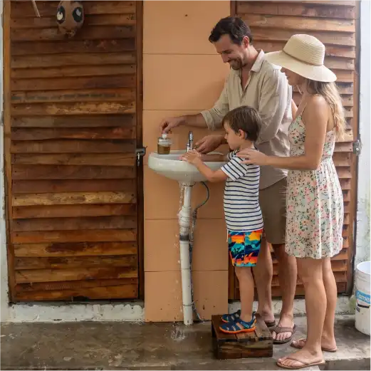 Familia lavándose las manos en las instalaciones de Palapa Mar Azul, con baños y regaderas disponibles en Playa de Monte Gordo