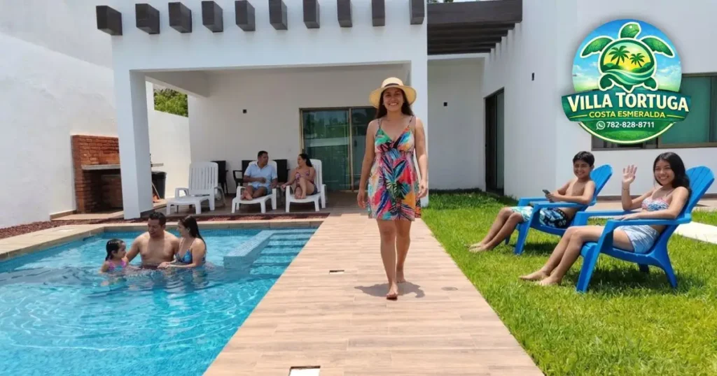 Familia disfrutando de la alberca privada con cascada en Villa Tortuga Costa Esmeralda, con jardín y asador.